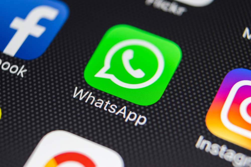 Photo of a phone screen featuring different social media applications. The WhatsApp logo is centre of the screen next to the Facebook logo on left and Instagram on the right